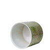 Ceramic cup with green and white pattern on a white background