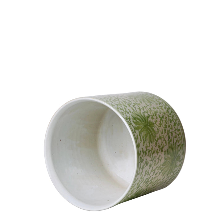 Ceramic cup with green and white pattern on a white background
