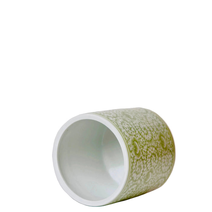 Green ceramic cup with white interior on a whitie background