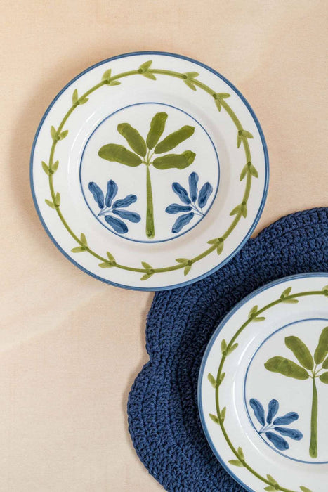 Two ceramic plates with decorative designs on a beige surface