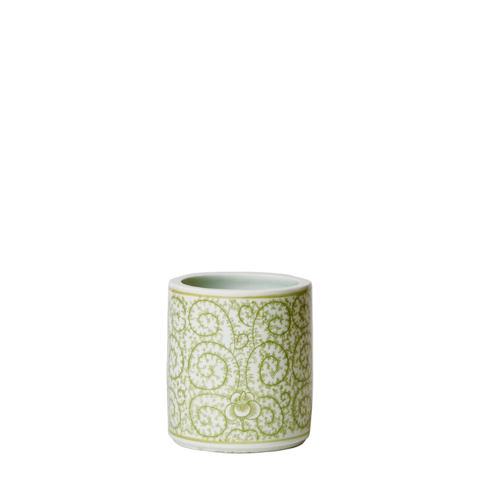 Green ceramic cup with decorative patterns on a white background