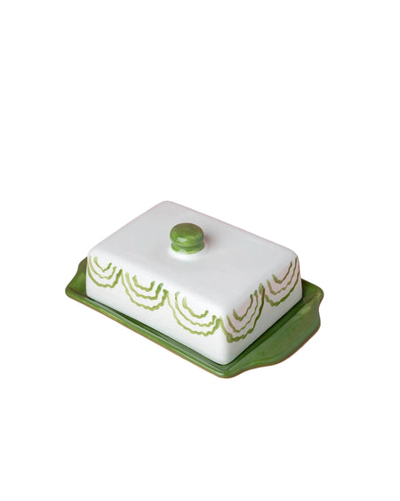 Butter dish with green lid and base on a pink background