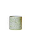 Ceramic mug with green and white pattern on a white background