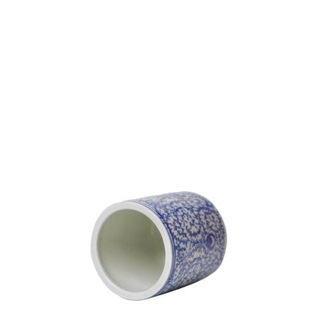 Cylindrical ceramic container with blue speckled pattern on a white background