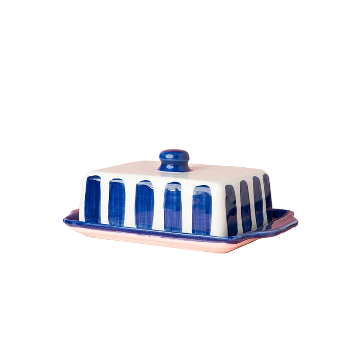 Butter dish with blue and white striped design on a pink background