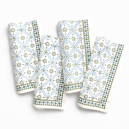 Four patterned napkins with green and blue designs on a white background
