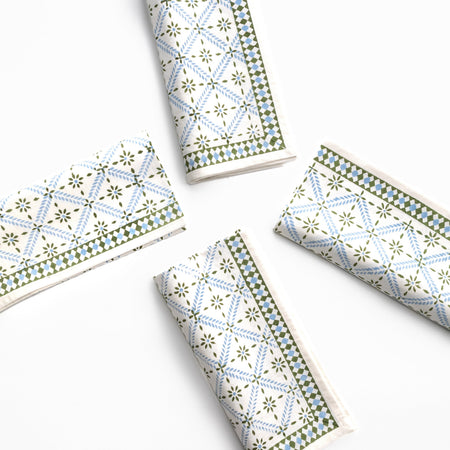 Four folded paper napkins with geometric patterns on a white background