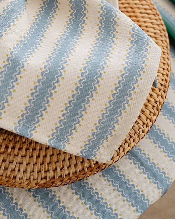 Fabric with blue and green wavy pattern on a woven surface