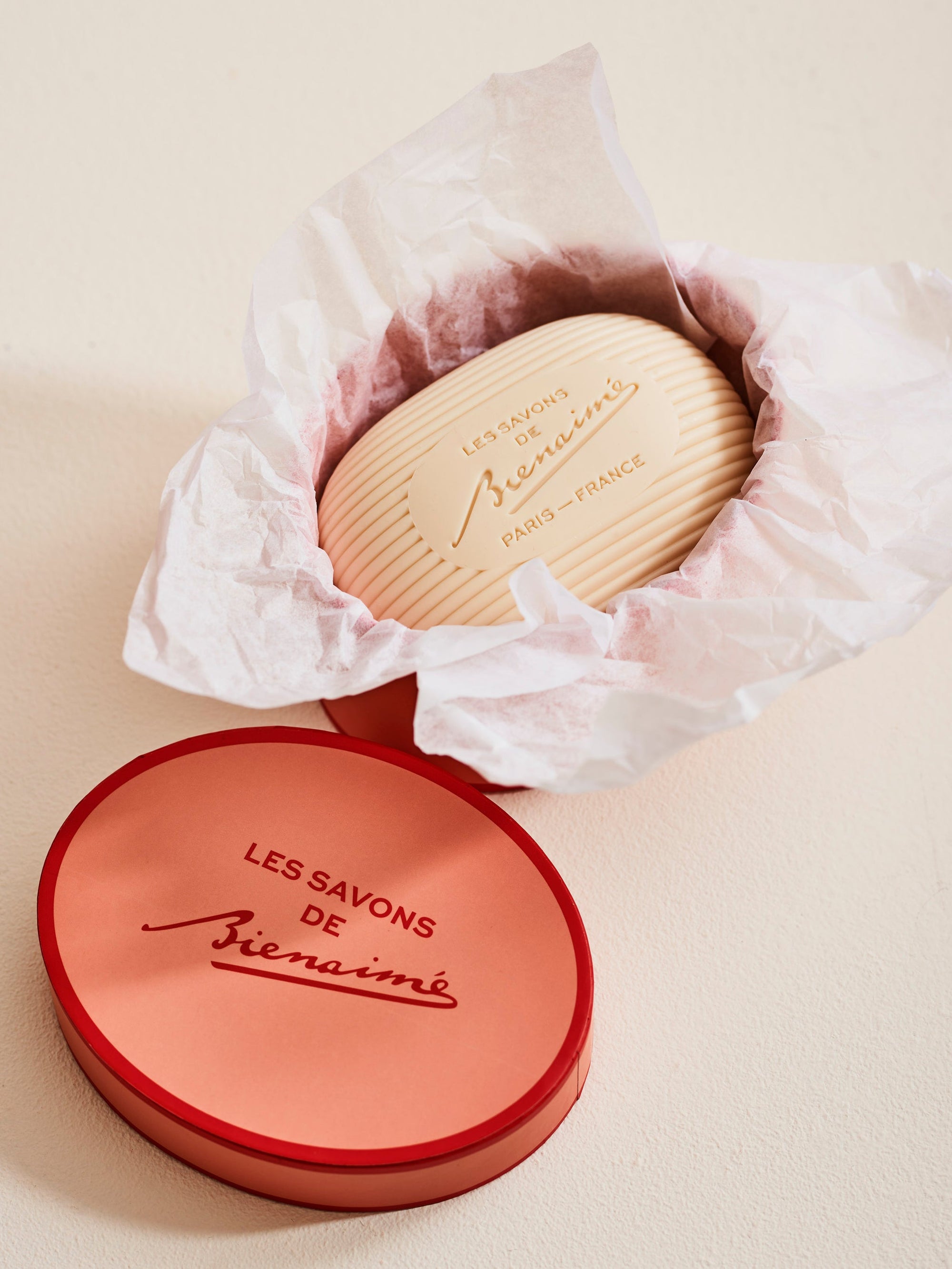 Soap in decorative box with tissue on cream background