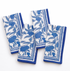 Set of four blue and white patterned towels on a white background