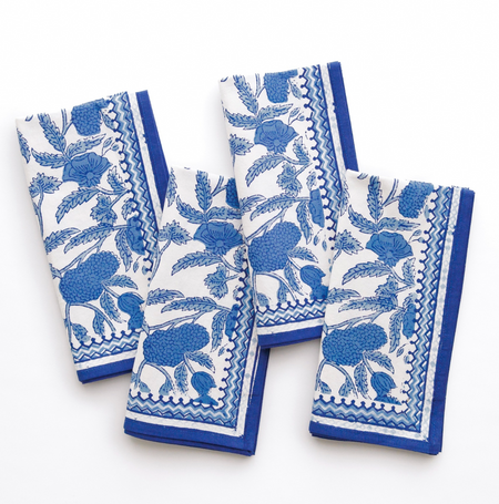 Set of four blue and white patterned towels on a white background
