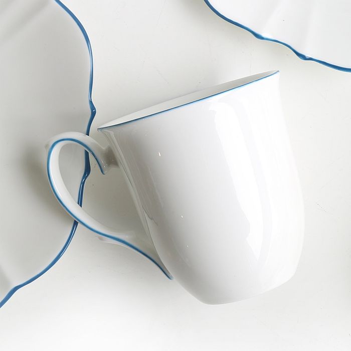 Coffee mug in white with blue trim on white background