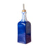 Blue glass bottle with a gold cap on a pink background