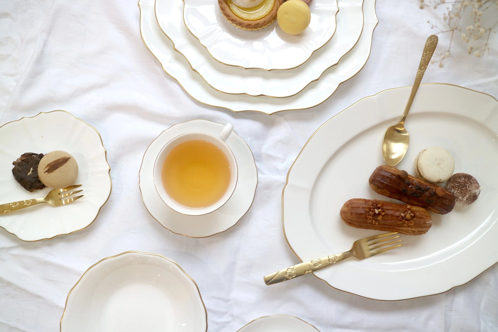 Brushed gold platter on table setting with desserts and plates.