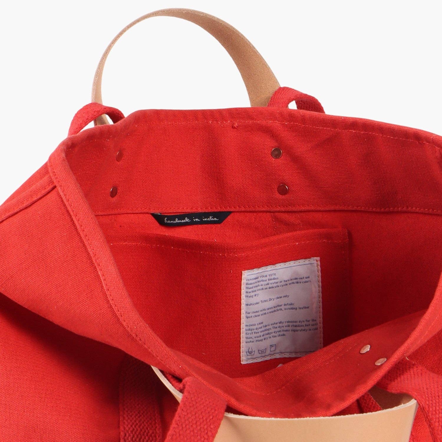 Inside of canvas tote showing pocket and leather detachable handles 