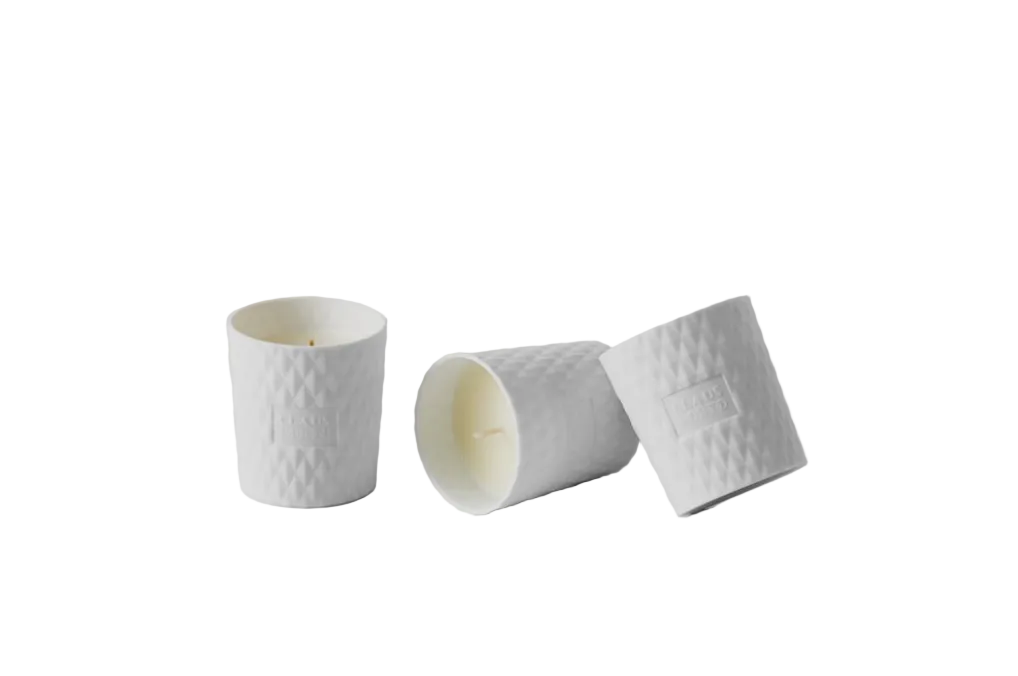 Three white textured ceramic cups on a light gray background