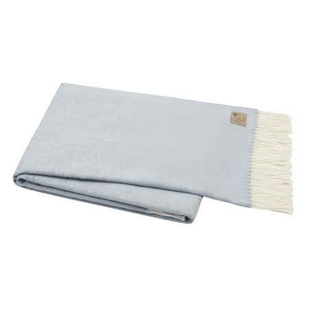 Folded light blue blanket with white edge on a white background