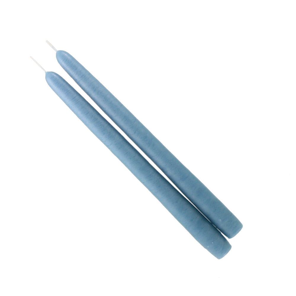 A pair of dusty blue taper candles on white background 