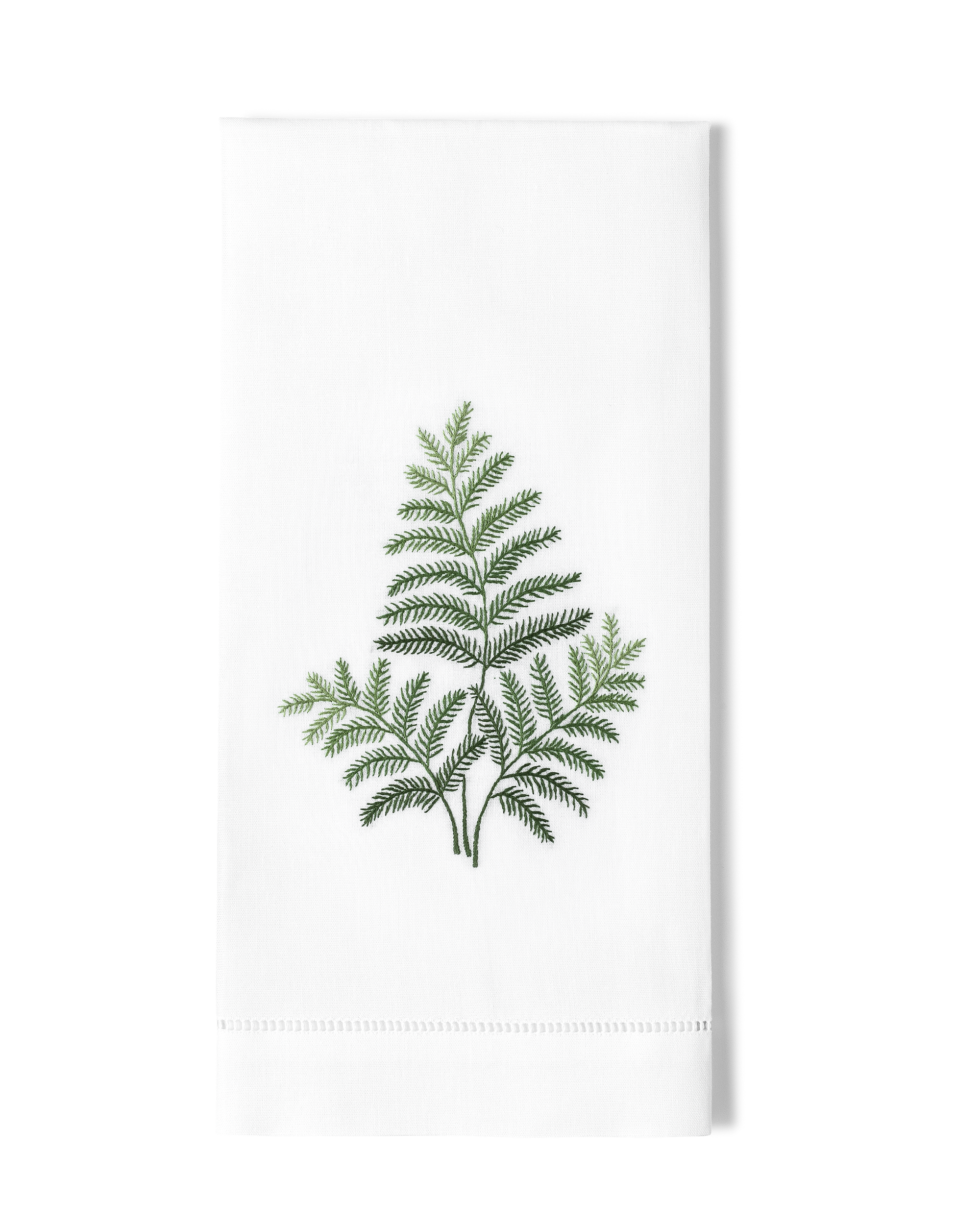 White towel with green fern design on a white background