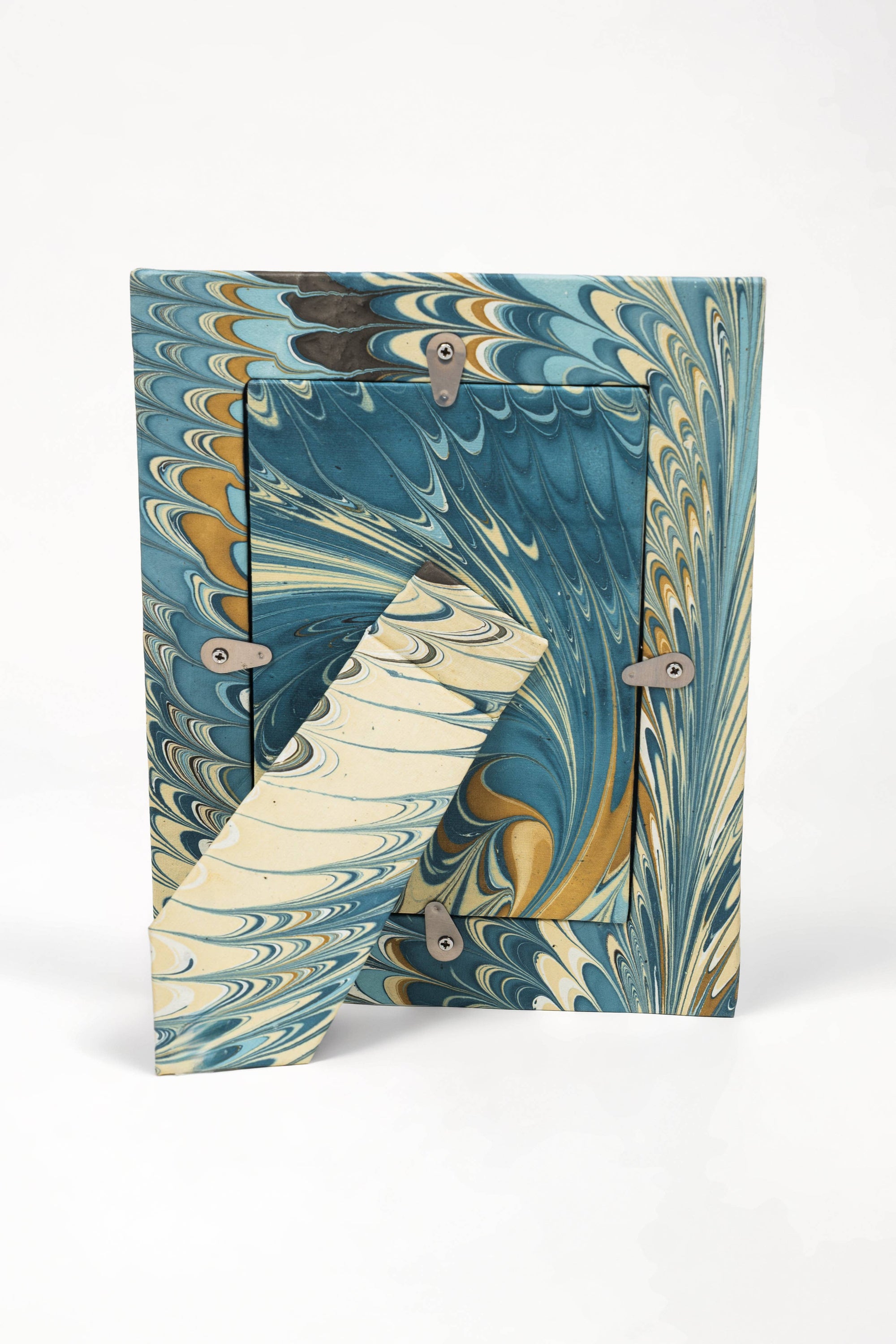 Back of hand marbled frame with stand in Nila feathers on white background 
