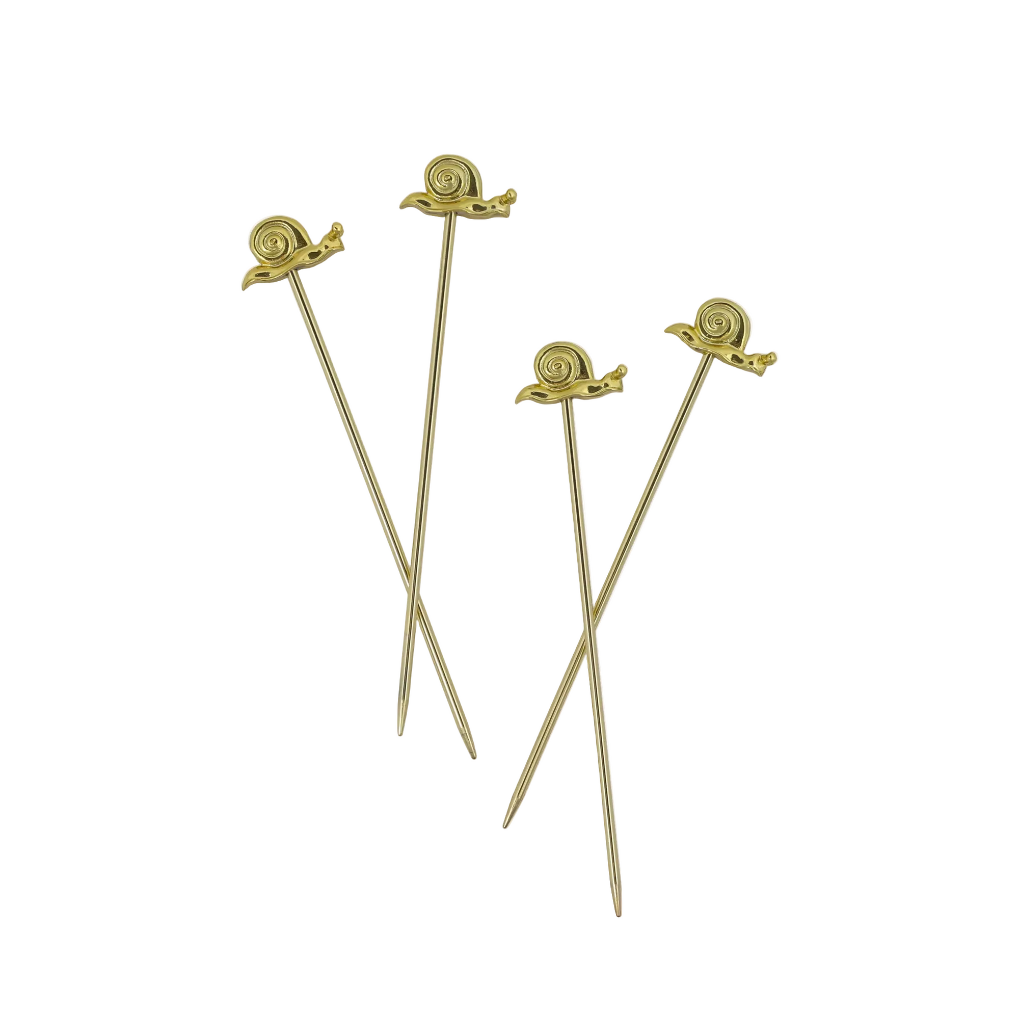 Four gold skewers with decorative ends on a white background