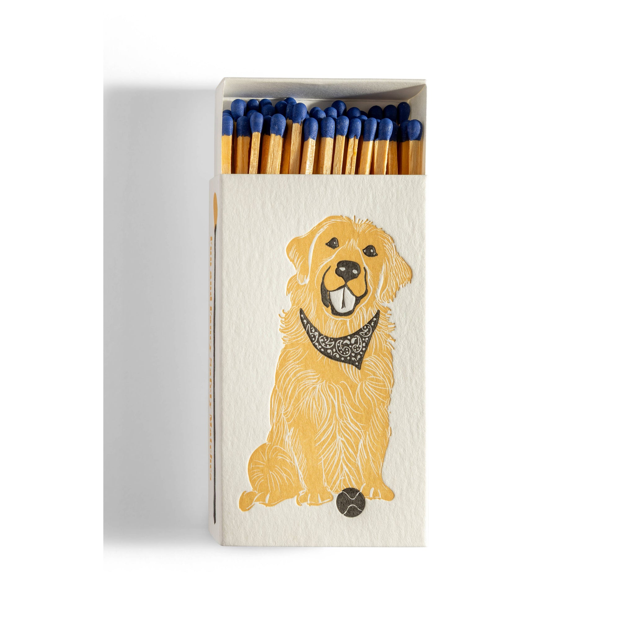 Matchbox with golden retriever on front with bandana and tennis ball on white background 