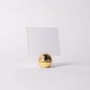 Gold textured holder with a white card on a light gray background