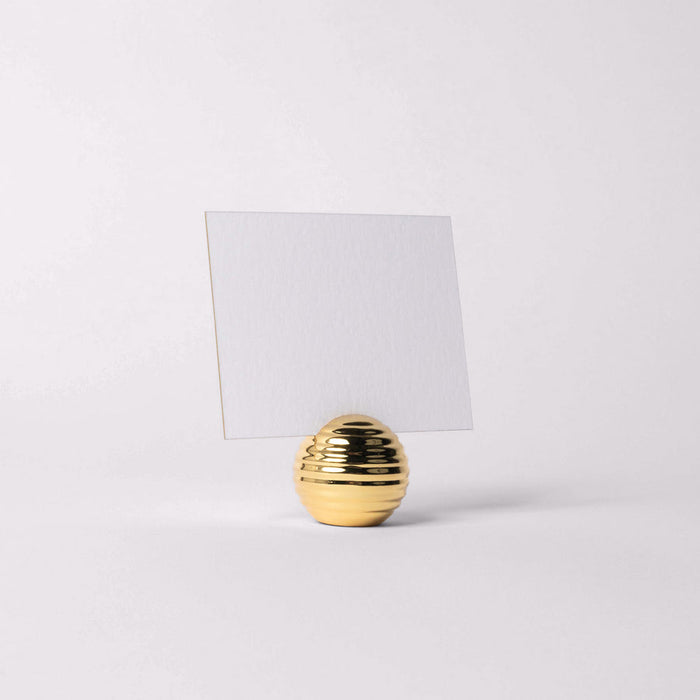 Gold textured holder with a white card on a light gray background
