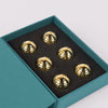 Set of gold spiral designs in a teal box on a light gray background