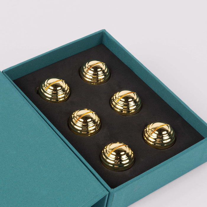 Set of gold spiral designs in a teal box on a light gray background