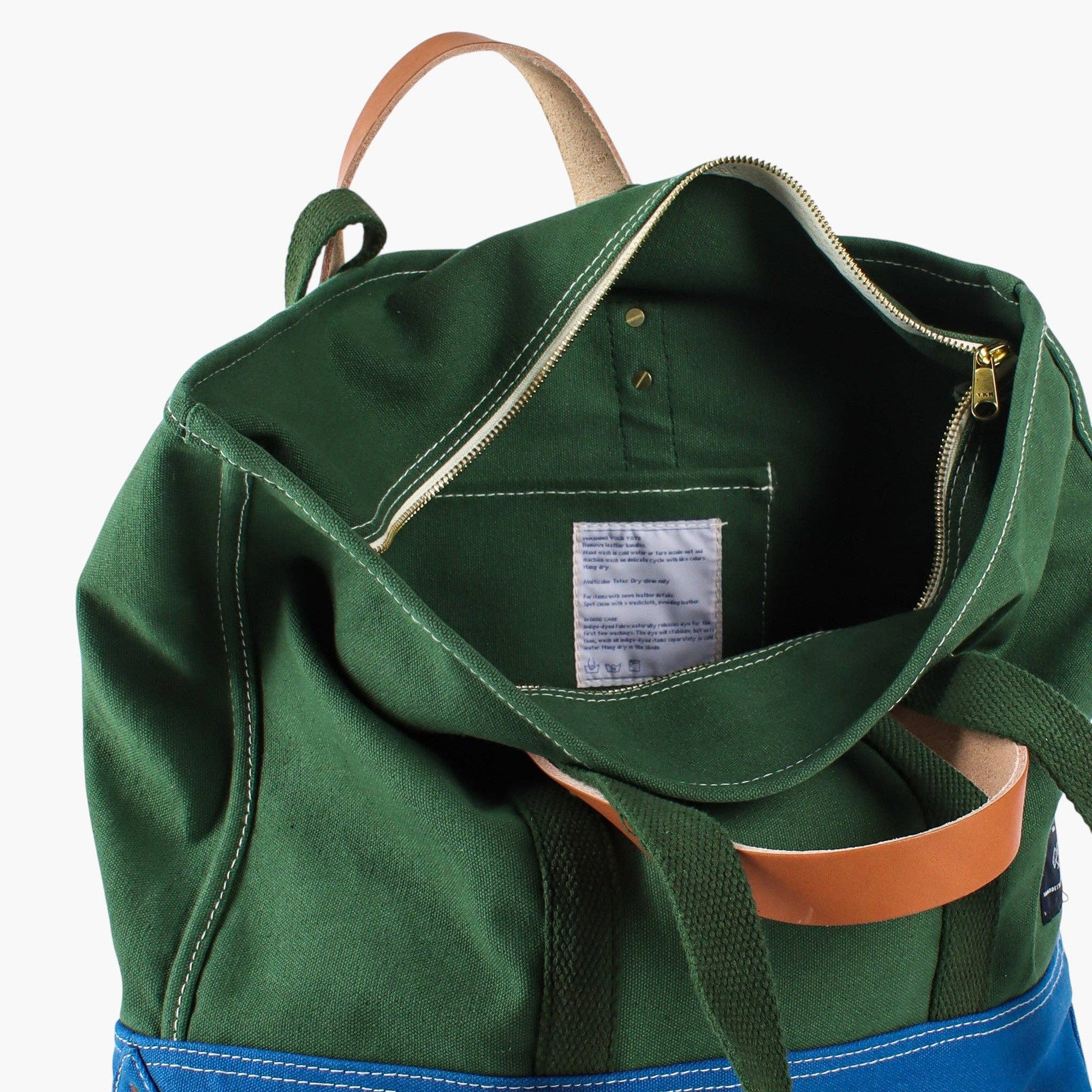 Green canvas bag with blue bottom and detachable leather handle and inside zipper and pocket 