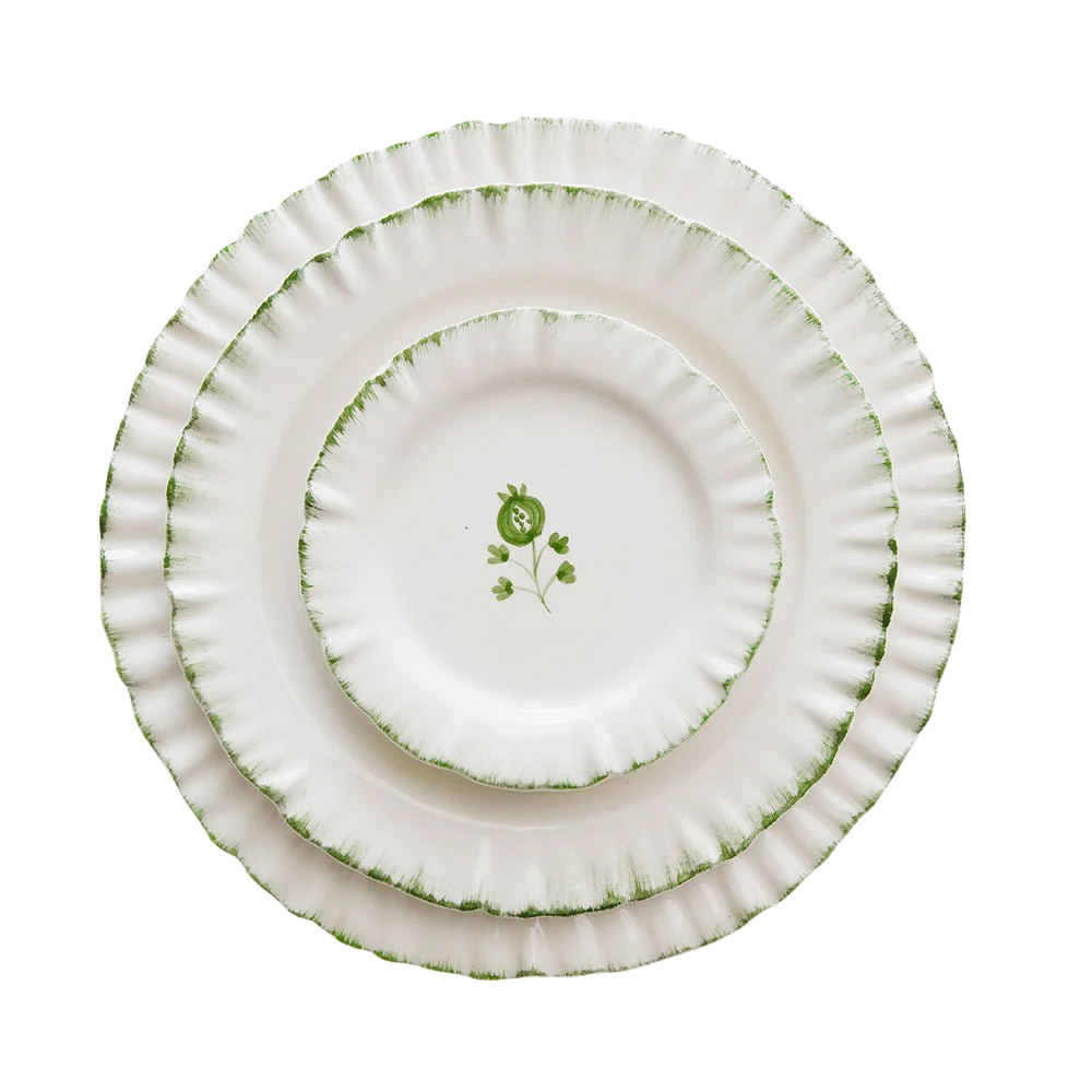 Set of three white plates with green decorative elements on a white background