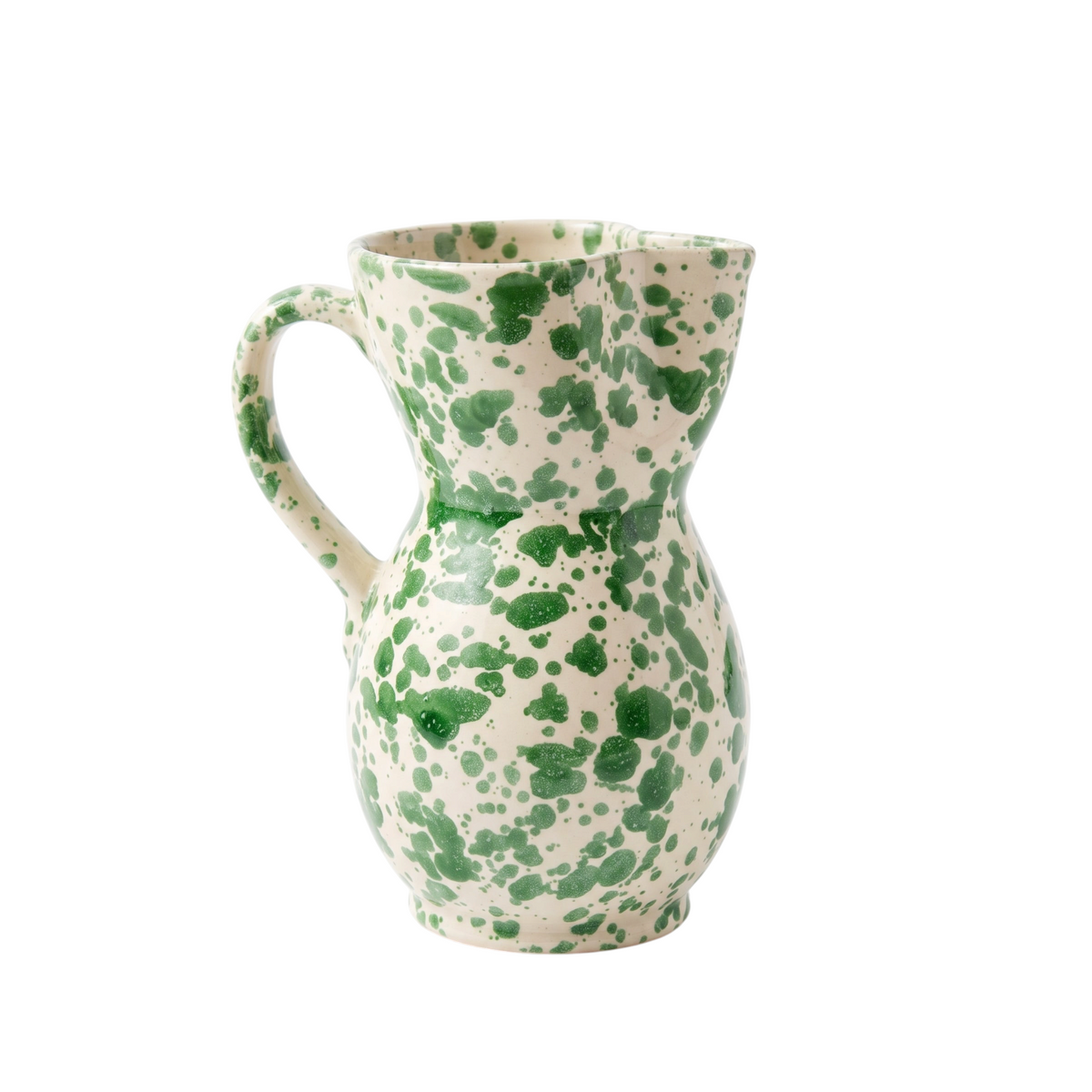 A handmade ceramic pitcher with a green speckled pattern on a cream-colored glaze, set against a plain white background.