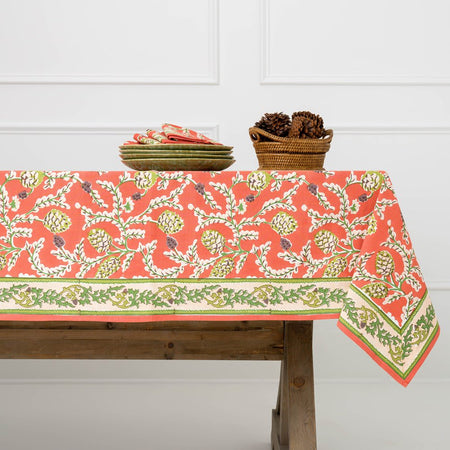 Tablecloth with floral pattern on a wooden table against a white wall