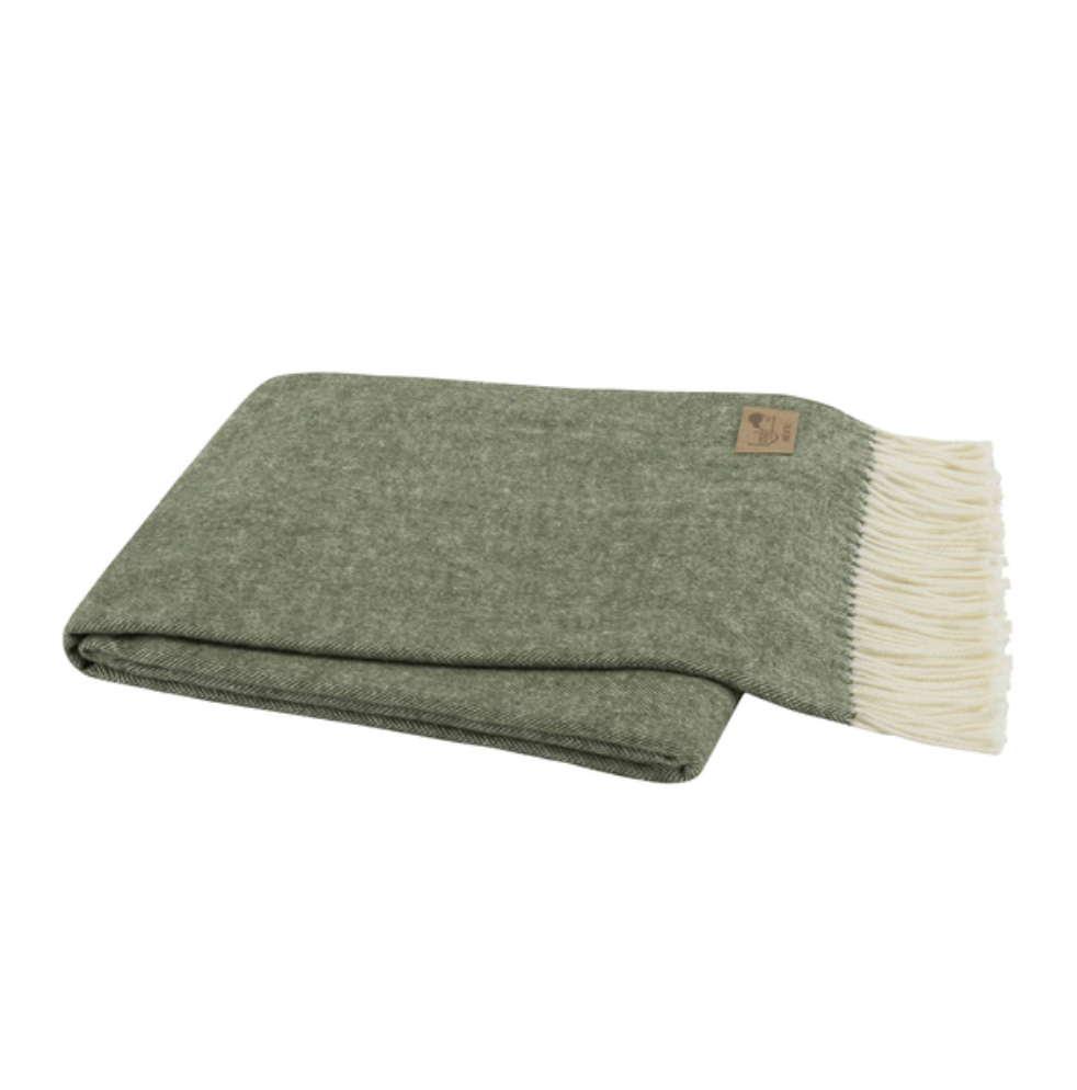 Folded green blanket with white fringe on a white background
