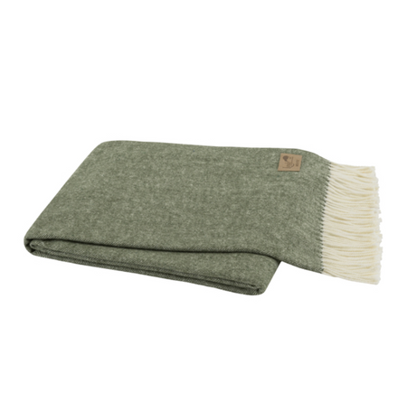 Folded green blanket with white fringe on a white background