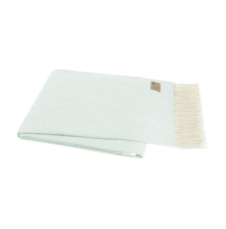 Light green blanket with white trim on a white background