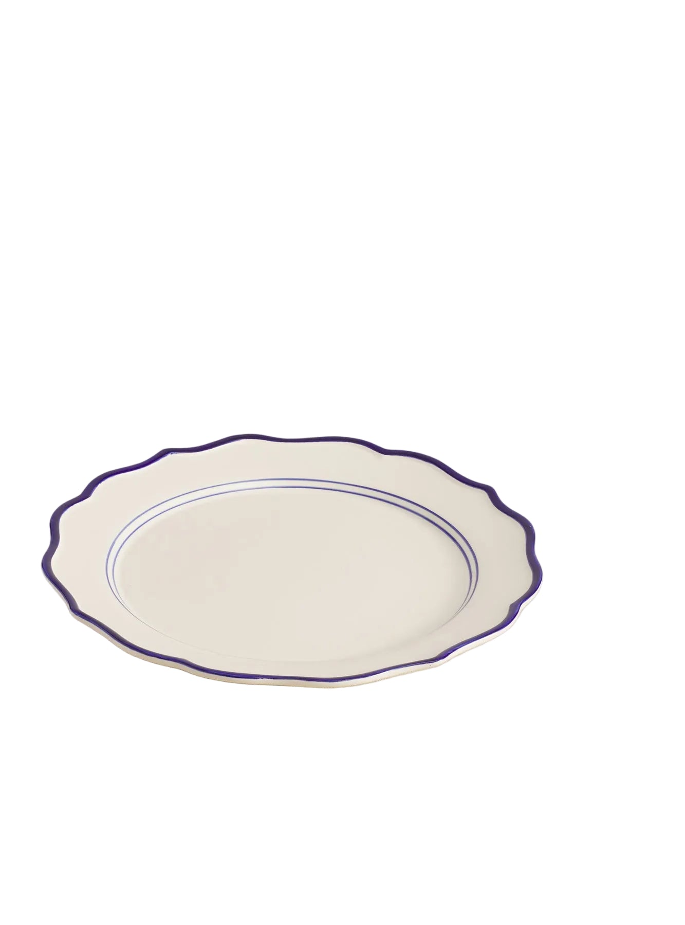 A round, white ceramic platter with blue trim on the edges, displayed on a beige textured surface.