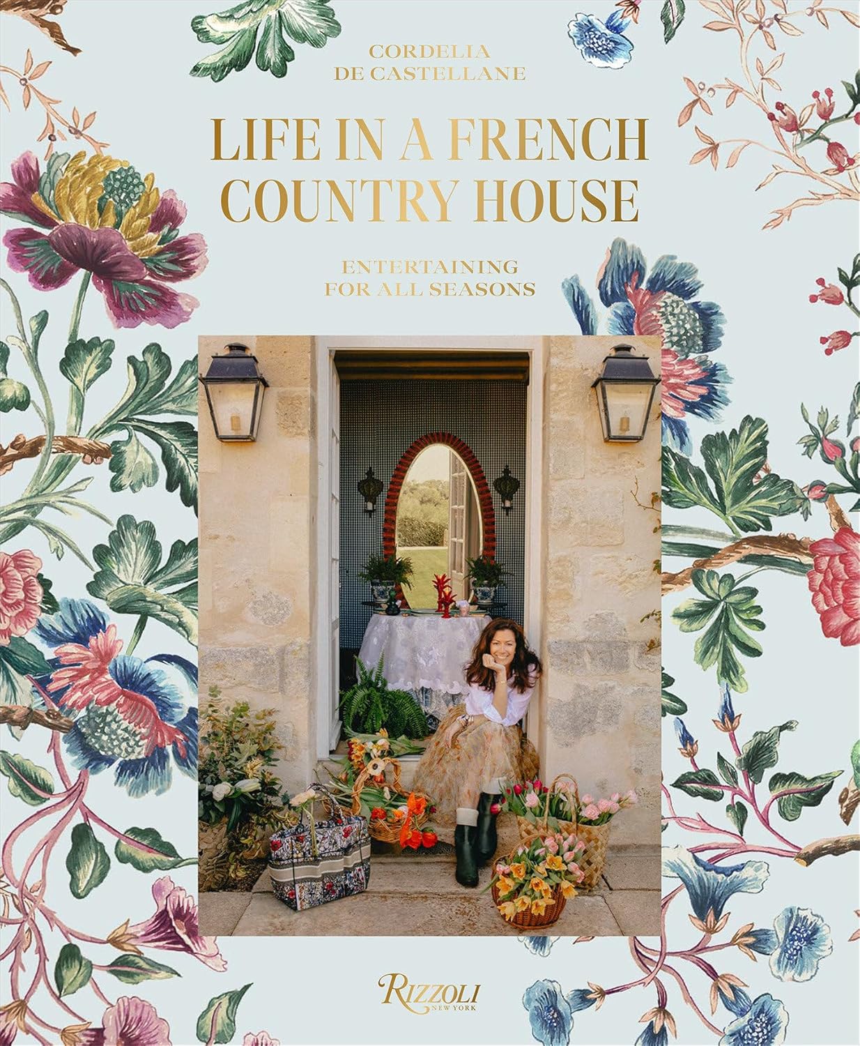 Life in a French Country House by Cordelia De Castellane book cover with flowers and author sitting in doorway of French home with baskets of flowers 