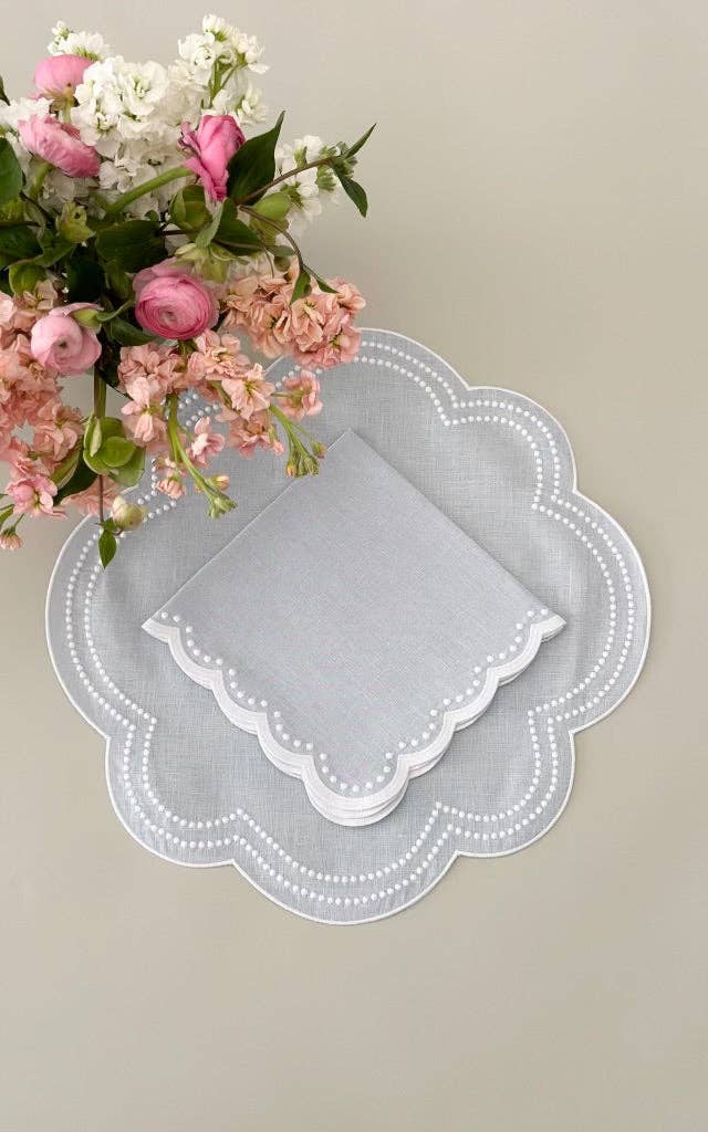 Decorative lace doily with a bouquet of pink and white flowers on a neutral background