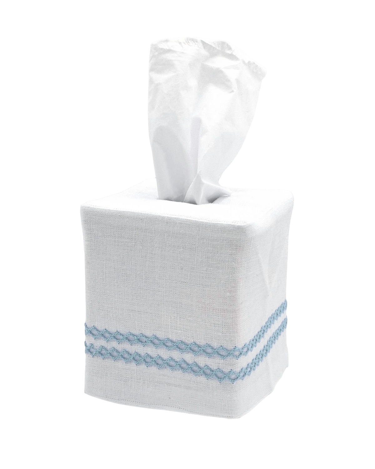A white linen tissue box cover with two light blue embroidered horizontal stripes near the bottom, holding a white tissue on a seamless white background.
