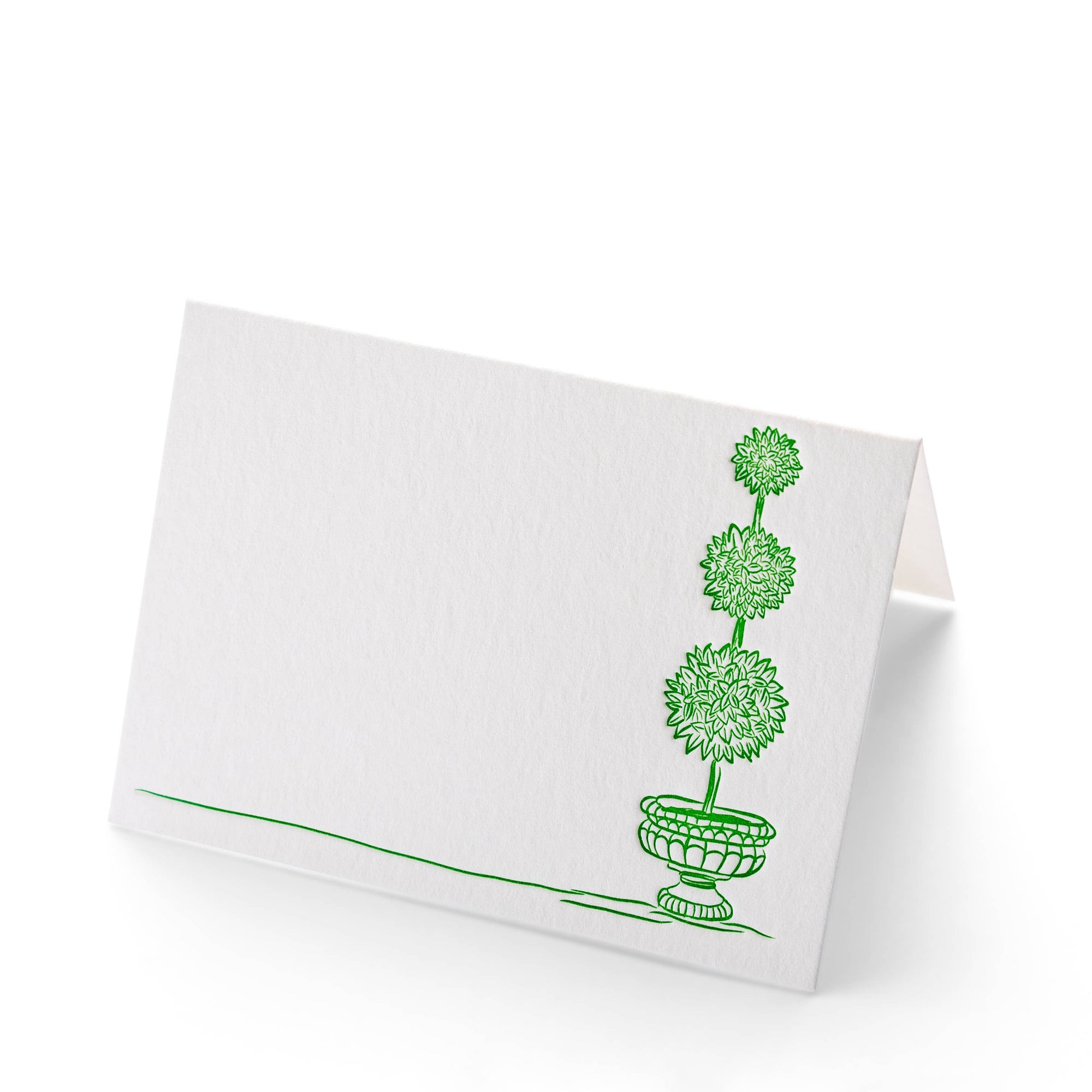 White card stock folding place cards with green topiary on front on white background 