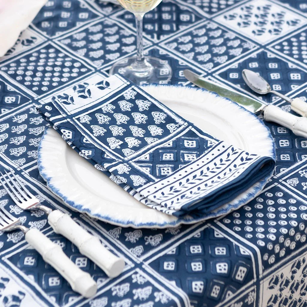 Blue and white patterned tablecloth with a folded napkin on a white plate.