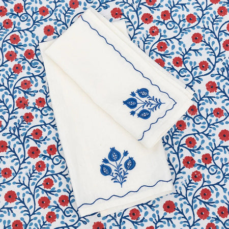 White card with blue floral design on a matching envelope, both on a red and blue floral patterned background.