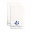 Two white towels with blue floral embroidery on a white background