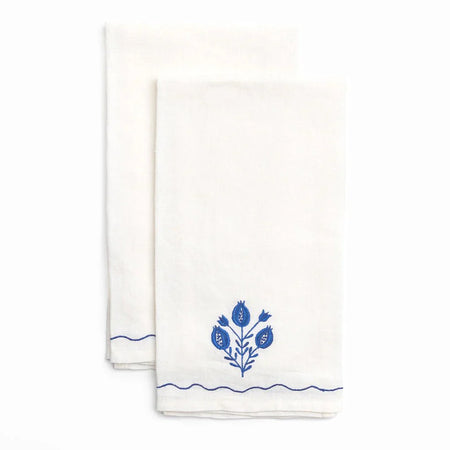 Two white towels with blue floral embroidery on a white background