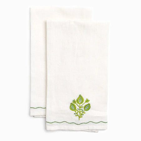 Two white towels with green leaf designs on a white background