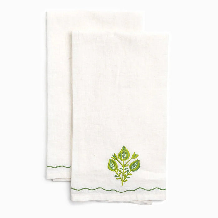 Two white towels with green leaf designs on a white background