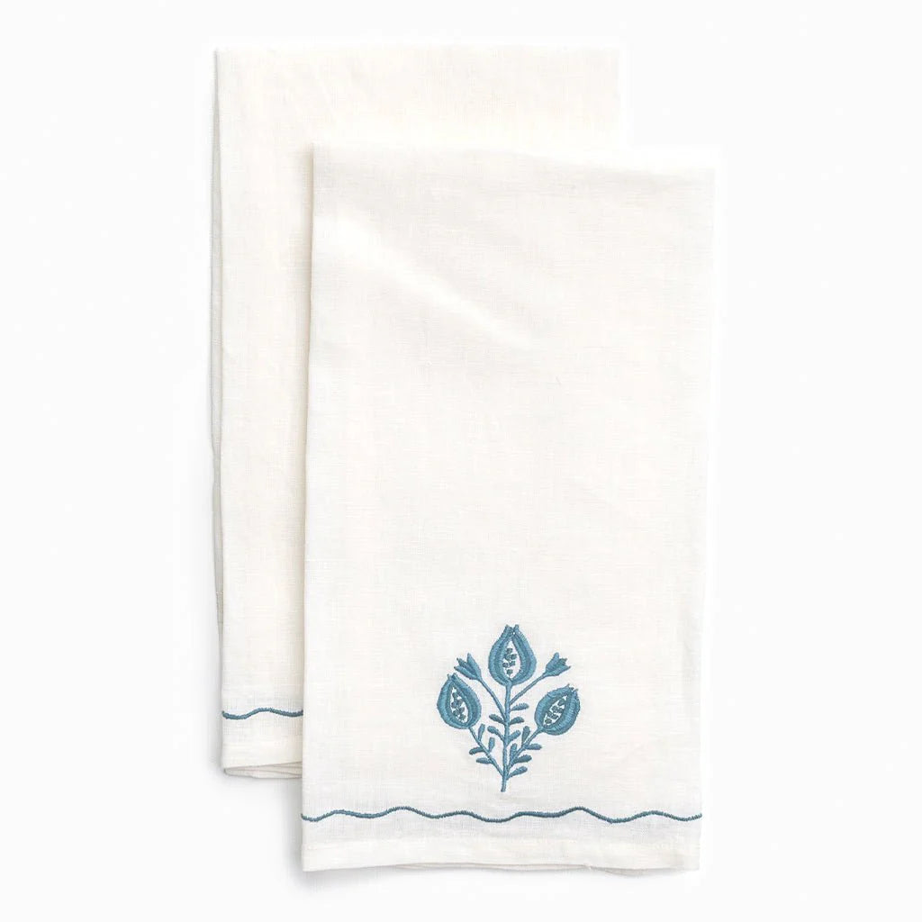 Two white towels with blue floral designs on a white background