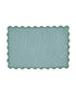 Rectangular green rug with scalloped edge on a white background